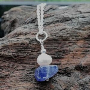 Blue rough nugget of Tanzanite, oval white pearl and sterling silver on a sterling silver chain. Pendant necklace.