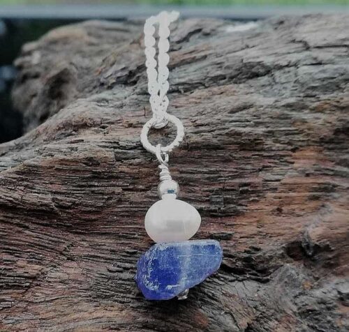 Blue rough nugget of Tanzanite, oval white pearl and sterling silver on a sterling silver chain. Pendant necklace.