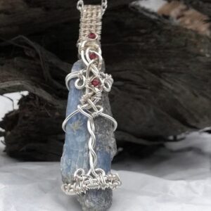 blue grey long stone with red stones woven on it
