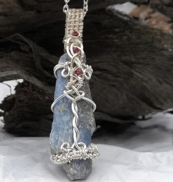 blue grey long stone with red stones woven on it