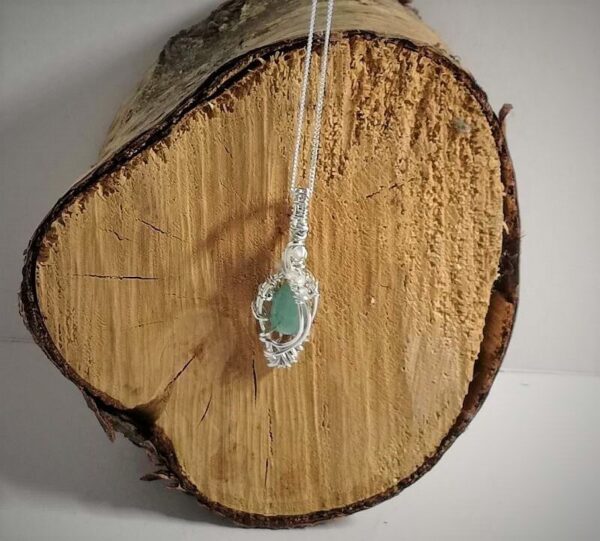 Pendant necklace of pale blue green Grandiderite with clear zircon. Wire wrapped with Sterling Silver on sterling silver chain.