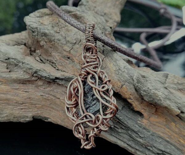 dark green Moldavite gemstone in copper wire. wire wrapped pendant jewellery.