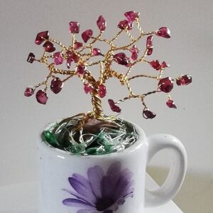 small tree of garnet and wire sitting in a mug