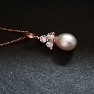 pearl drop on a 3 stone triangle. Rose gold metal