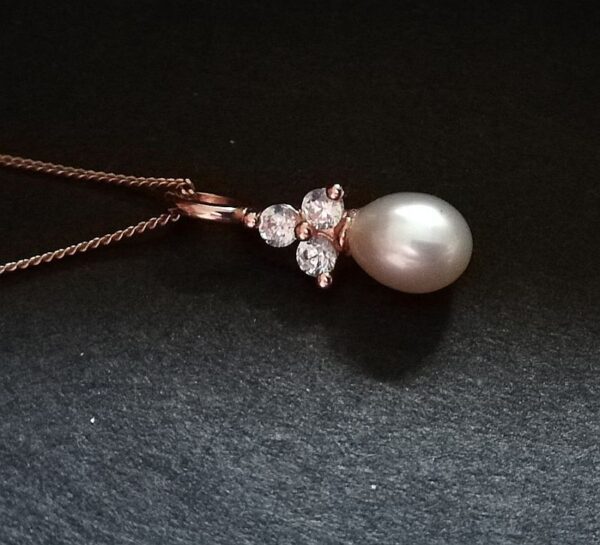 pearl drop on a 3 stone triangle. Rose gold metal