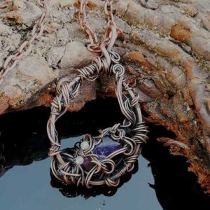 purple stone in copper wire with small white stones. pendant necklace on chain.