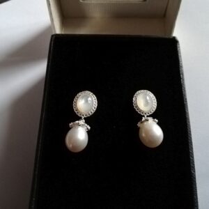 White pearl mother of pearl topaz earrings on black background