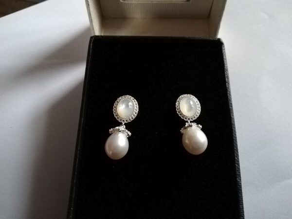 White pearl mother of pearl topaz earrings on black background